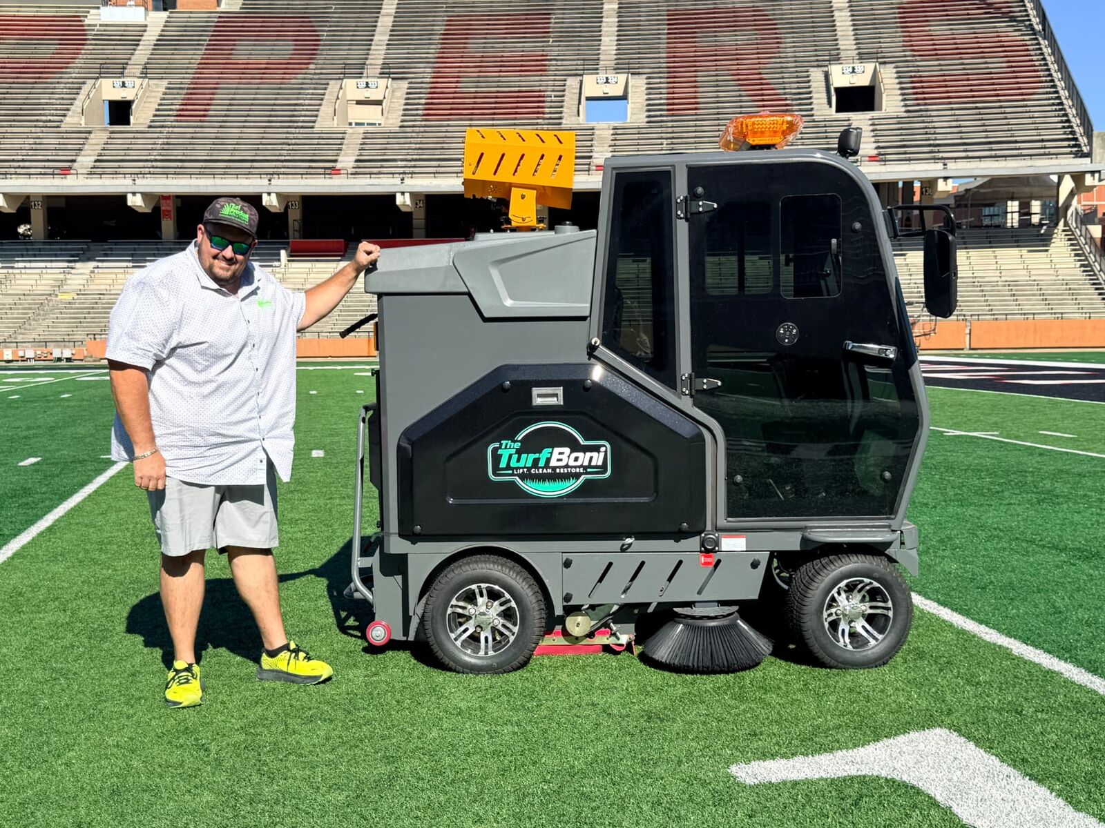 Founder Nick Ogilvie standing beside the TurfBoni at a stadium